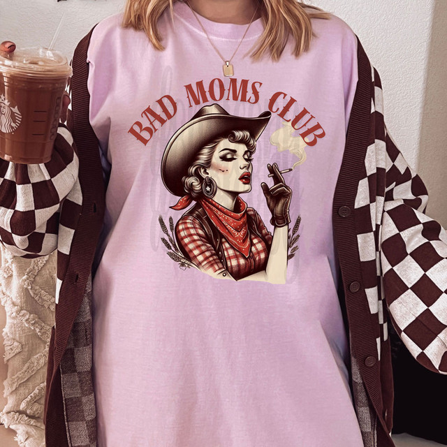 Bad Moms Club Western DTF Heat Transfer, graphic design of a vintage woman wearing a cowboy hat and scarf smoking a cigarette on a pink T-shirt.