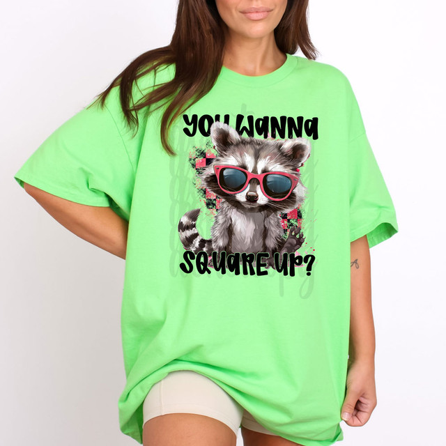 You Wanna Square Up? DTF Heat Transfer - Colorful graphic of a cute raccoon wearing sunglasses on bright green oversized t-shirt.