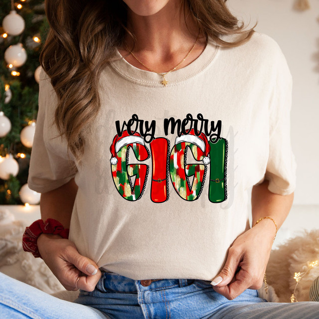 Very Merry Gigi DTF Heat Transfer, Christmas-themed holiday design on a woman's t-shirt, featuring festive colorful socks with Santa hats and the phrase 'Joy Mery' for holiday celebrations.