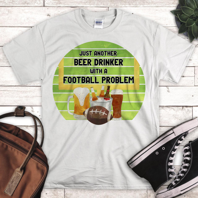 Just another beer drinker with a football problem sublimation transfer, T-shirt design featuring beer mugs, beer bottles, a football, and text on a green striped background.