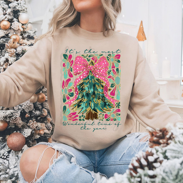 It's The Most Wonderful Time Of The Year Faux Glitter Tree DTF Heat Transfer, a festive Christmas design featuring a decorated Christmas tree with a pink bow, colorful flowers, and holiday message on a beige sweatshirt.