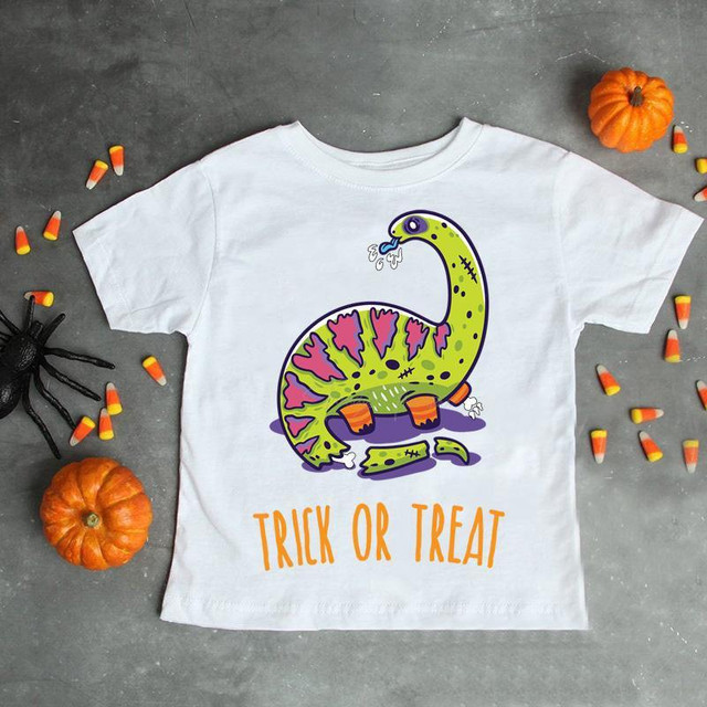 Zombie Dinosaur Halloween Sublimation Transfer, Halloween themed T-shirt with a cartoon zombie dinosaur illustration and 'Trick or Treat' text