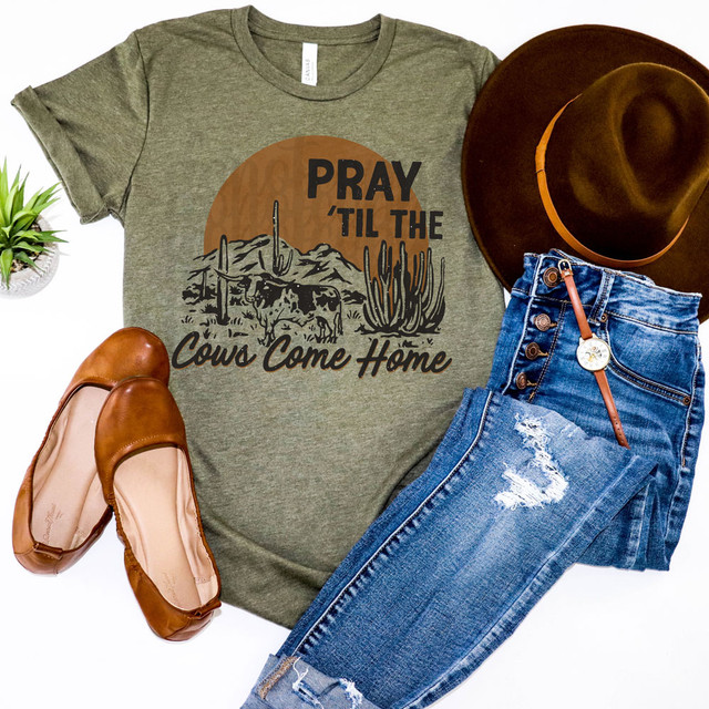 Pray 'Til The Cows Come Home Western DTF Heat Transfer T-shirt, olive green with graphic design of cows and cacti in a desert scene with sunset background.
