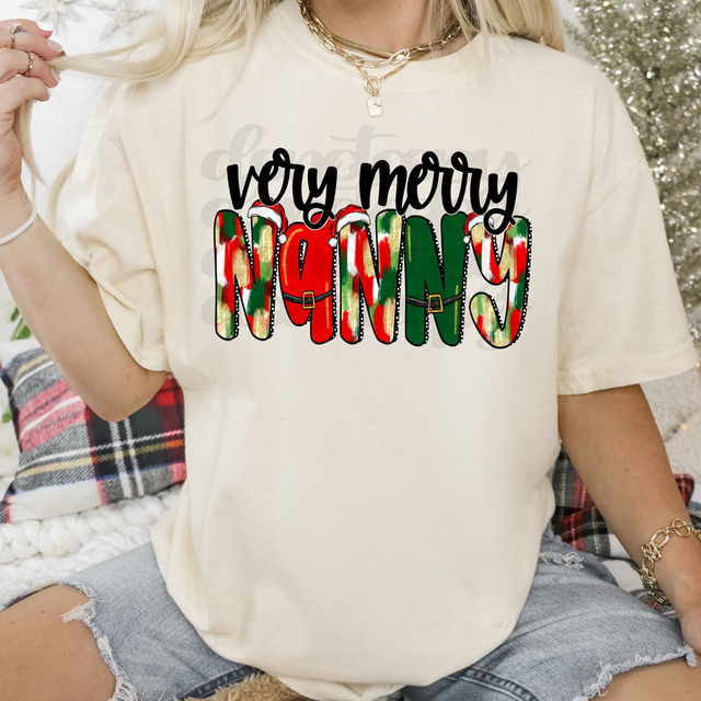 Very Merry Nanny DTF Heat Transfer, Christmas-themed holiday design with colorful Santa belt-inspired lettering on a woman's t-shirt.