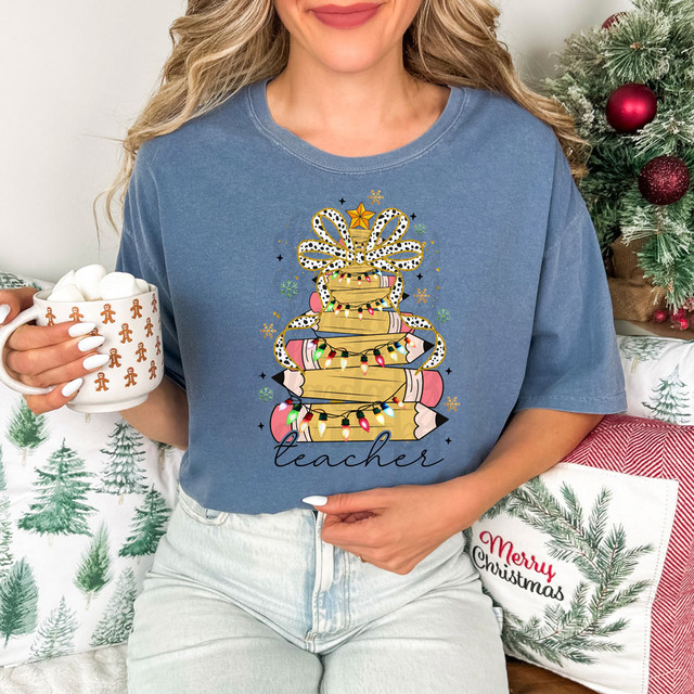 Teacher Christmas Tree DTF Heat Transfer, holiday-themed design featuring a Christmas tree decorated with colorful lights, a gift bow on top, and the word 'teacher' written below.