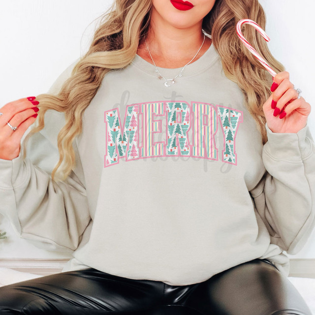 Preppy Merry DTF Heat Transfer, festive Christmas-themed design with colorful pattern and text on a woman's sweatshirt.