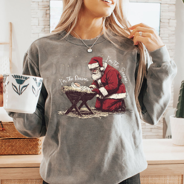 I'm The Reason I'm The Season WHITE DTF Heat Transfer, Christmas-themed sweatshirt featuring Santa Claus and a nativity scene.