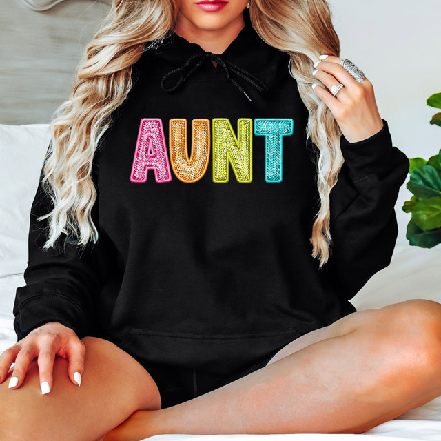 Bright Groovy Aunt Faux Sequins DTF Heat Transfer, colorful sequin embellished text on a black hoodie.