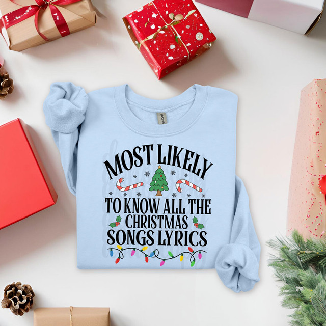 Most Likely To Know All The Christmas Song Lyrics Festive DTF Heat Transfer, light blue Christmas-themed T-shirt with holiday graphics and text.