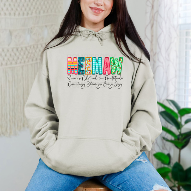 Meemaw She Is Clothed In Gratitude Counting Blessings Every Day DTF Heat Transfer, woman wearing a hoodie with colorful word 'Meemaw' and black script text on front.
