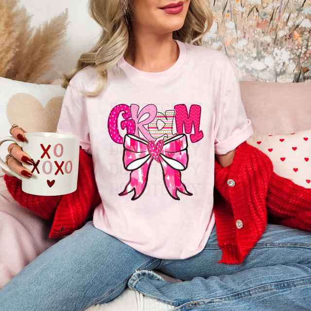 Gram Valentine Coquette DTF Heat Transfer, pink and white graphic design with a bow and the word 'Glam' on a white t-shirt.