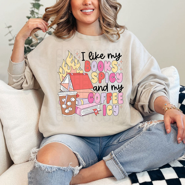 Product I Like My Books Spicy & My Coffee Icy Retro DTF Heat Transfer, colorful illustration of a stack of books with flames and iced coffee on a beige sweatshirt.