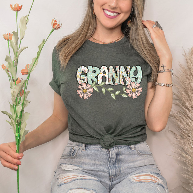 Granny Easter Pattern DTF Heat Transfer, colorful floral design with the word 'Granny' on a dark gray T-shirt worn by a smiling woman.