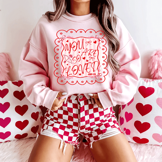 You Are So Loved Valentine's Day DTF Heat Transfer, red and pink greeting design on a woman's pink sweatshirt.