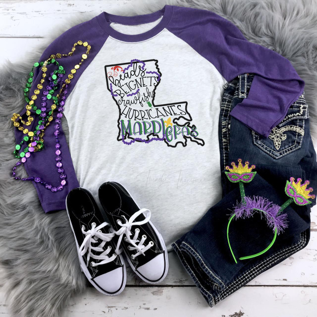 Mardi Gras LA Map Sublimation Transfer, purple and white long sleeve shirt with Mardi Gras themed design, surrounded by Mardi Gras beads, decorated headbands, and sneakers.