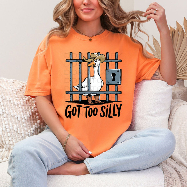 Got Too Silly DTF Heat Transfer, illustrated cartoon of a goose wearing a cowboy hat and boots behind jail bars with the caption 'Got Too Silly' on an orange T-shirt.