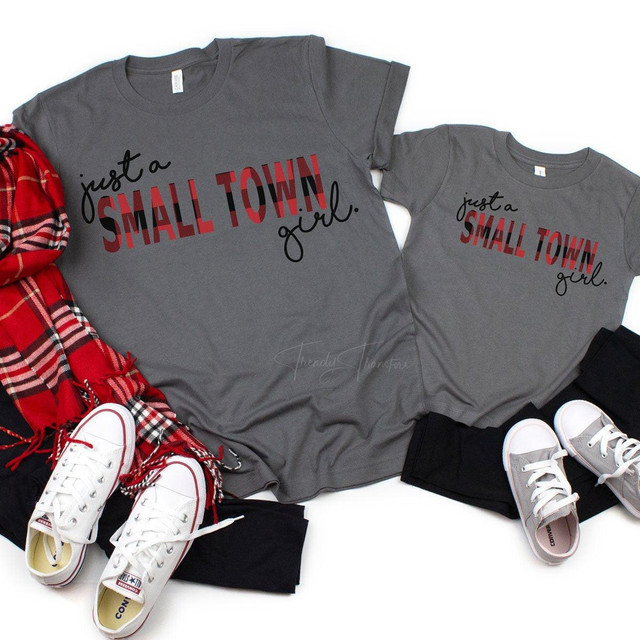 Just a Small Town Girl FINAL STOCK -YOUTH Screen Print Transfer T-shirt, featuring a gray youth T-shirt with the text 'just a SMALL TOWN girl' in black and red letters, displayed alongside sneakers, black pants, and a red plaid scarf, highlighting the product's style and design.