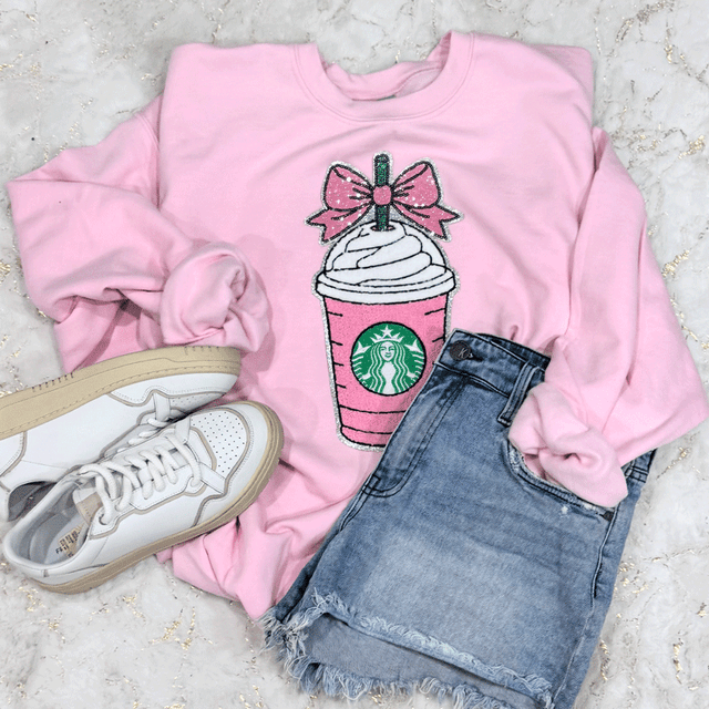 Pink Drink Coquette Sequins Patch, pink sweatshirt with a Starbucks drink design adorned with sequins, paired with denim shorts and white sneakers.