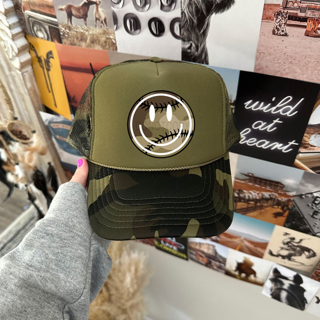Camo Baseball Happy Face DTF Heat Transfer, green camouflage trucker hat with a smiling face patch featuring eyelashes and stitched mouth design.