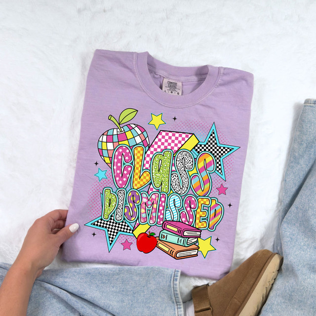 Retro Class Dismissed DTF Heat Transfer, colorful school-themed design on a purple t-shirt featuring an apple, books, stars, and text.