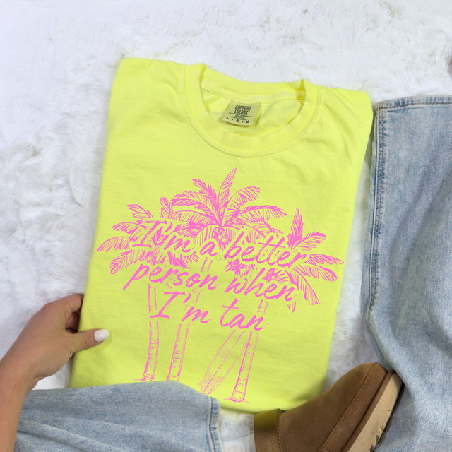 I'm A Better Person When I'm Tan Palm Trees DTF Heat Transfer, a yellow t-shirt with a pink palm tree and script design that reads 'I'm a better person when I'm tan'.