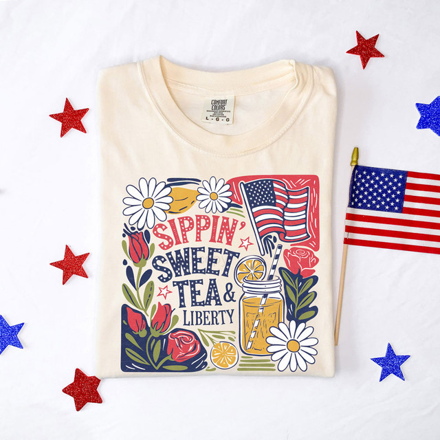 Sippin' Sweet Tea & Liberty DTF Heat Transfer, a colorful design on a cream-colored T-shirt featuring patriotic and floral elements with an American flag, a mason jar of sweet tea, and daisies.