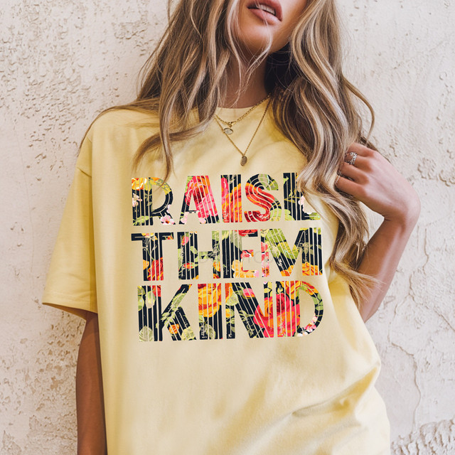 Raise Them Kind Floral DTF Heat Transfer, colorful floral design text on a yellow t-shirt.