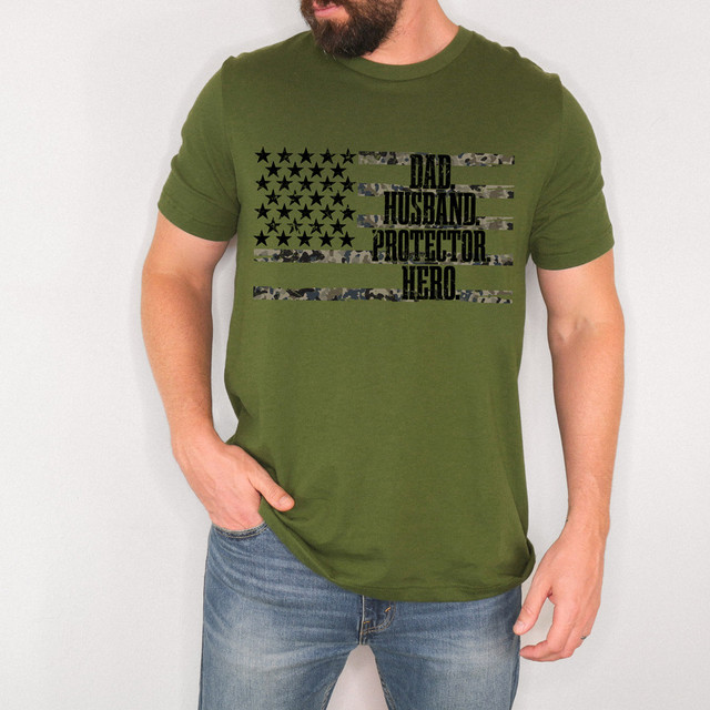 Dad Husband Protector Hero Camo Flag DTF Heat Transfer, man wearing a green t-shirt with a camouflage flag design and text.