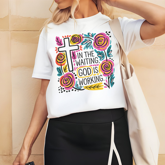 In The Waiting God Is Working Boho DTF Heat Transfer, colorful floral and religious design on a white T-shirt worn by a woman.
