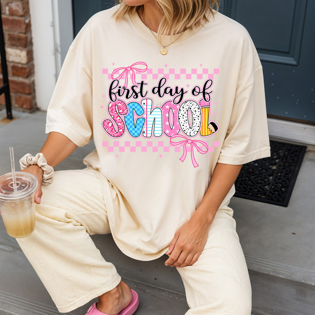 First Day Of School Bow DTF Heat Transfer, colorful and playful design with bows and checkered pattern on a beige T-shirt for back-to-school.