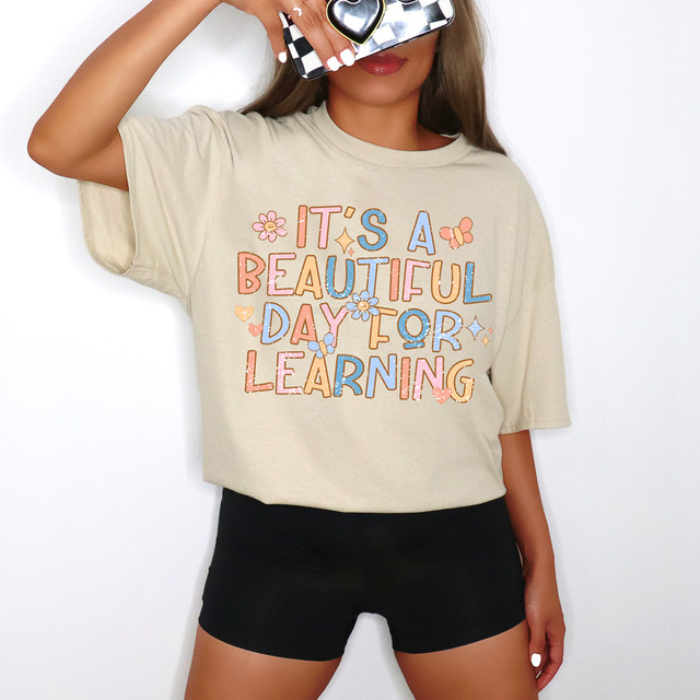 It's A Beautiful Day For Learning Boho DTF Heat Transfer, woman wearing a beige t-shirt with colorful text and floral designs