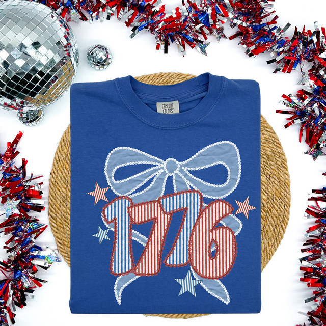 1776 Lace Bow DTF Heat Transfer, a patriotic-themed design featuring a lace bow, stars, and the number 1776 printed on a blue T-shirt.