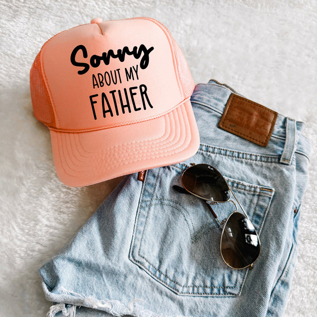 Sorry About My Father DTF Heat Transfer, pink trucker cap with text design and denim jeans with sunglasses.