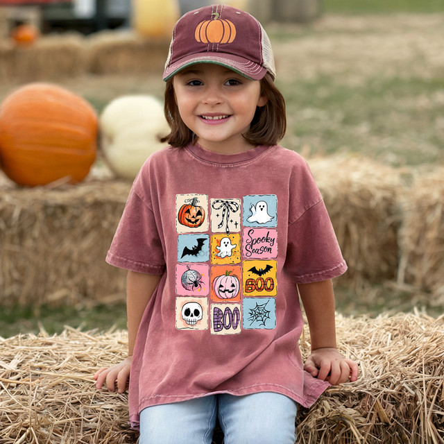 Cute Halloween Color Block DTF Heat Transfer, a colorful patchwork design featuring pumpkins, ghosts, bats, spiders, skulls, web, and Halloween phrases on a child's t-shirt for festive seasonal apparel.
