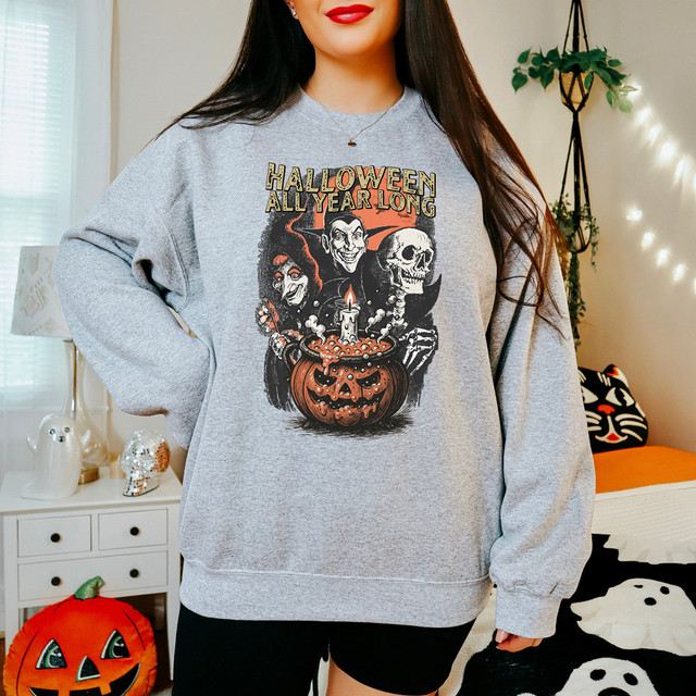 Halloween All Year Long DTF Heat Transfer, Halloween-themed graphic featuring witches, a skull, and a pumpkin candle on a gray sweatshirt.