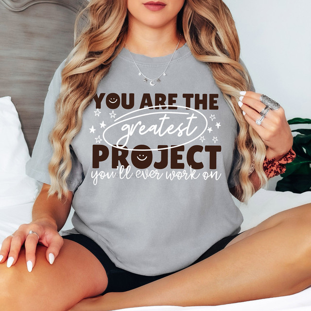 You Are The Greatest Project DTF Heat Transfer T-shirt, featuring a woman wearing a gray T-shirt with the positive quote "You Are The Greatest Project You'll Ever Work On".
