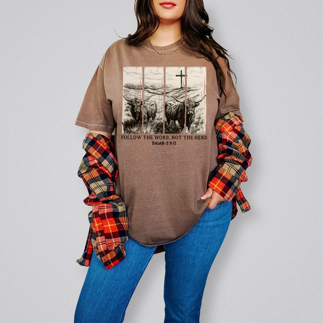 Follow The Word, Not The Herd DTF Heat Transfer, image of a woman wearing a brown T-shirt with a graphic design of cattle and a cross, featuring a biblical quote.