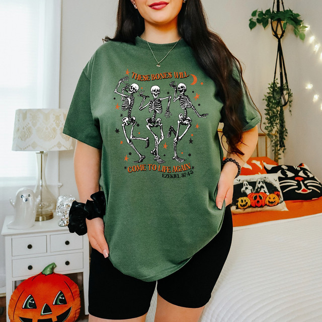These Bones Will Come To Life Again DTF Heat Transfer, Halloween themed skeletons dancing on a green t-shirt.