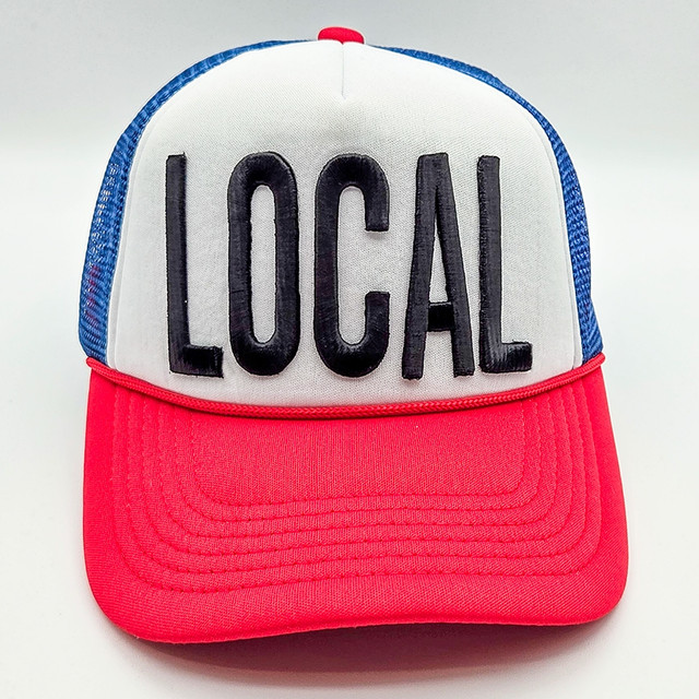 LOCAL Puff Embroidered HAT/POCKET Patch, trucker hat featuring a white front panel with black embroidered 'LOCAL' text and a red brim, blue mesh back.