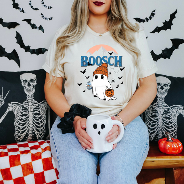 Bosch Beer Ghost DTF Heat Transfer, Halloween-themed graphic featuring a cute ghost wearing a knit hat, holding a pumpkin basket, surrounded by bats with mountain background.