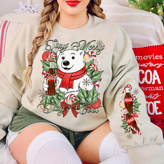 Stay Merry, Stay Cool Cola SET DTF Heat Transfer, festive Christmas-themed sweatshirt featuring a cartoon polar bear holding a Coca-Cola bottle, surrounded by candy canes, holly leaves, and snowflakes.