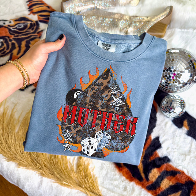 Mother Grunge DTF Heat Transfer, a graphic design of a bear's face with a leopard print pattern, flaming accents, and dice, printed on a blue t-shirt.