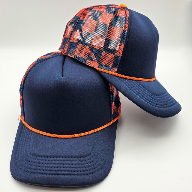 Navy & Orange Checkered Foam Trucker Hat, sporting a checkered pattern on the mesh panel and a solid navy brim with orange trim.