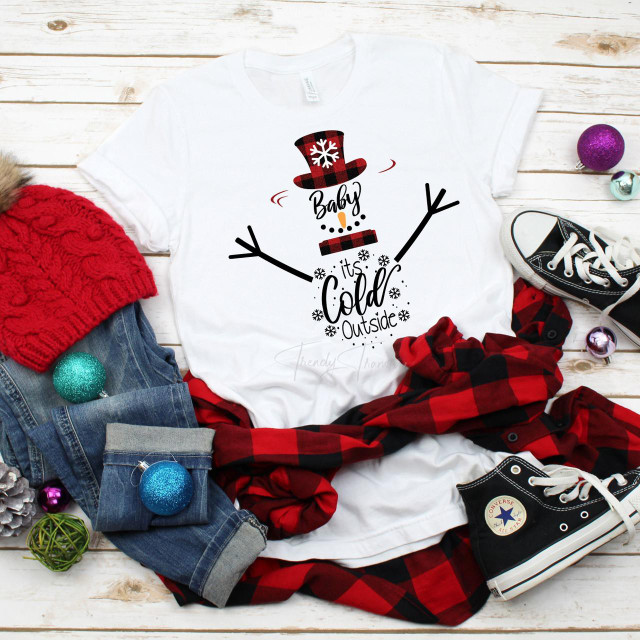 Baby it's Cold Outside Snowman Plaid Sublimation Transfer, Christmas-themed snowman graphic on a white t-shirt with plaid and winter accessories surrounding it.