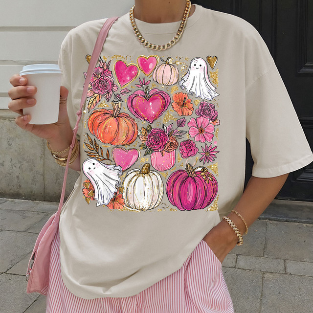 Pumpkins, Hearts & Ghost Collage DTF Heat Transfer, colorful Halloween-themed design on a woman's t-shirt with pumpkins, hearts, flowers, and ghost illustrations.