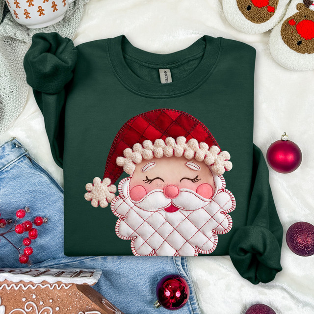 Cozy Patchwork Santa DTF Heat Transfer, Christmas-themed heat transfer design featuring a cheerful Santa Claus face with a quilted hat, on a green t-shirt surrounded by holiday decorations.
