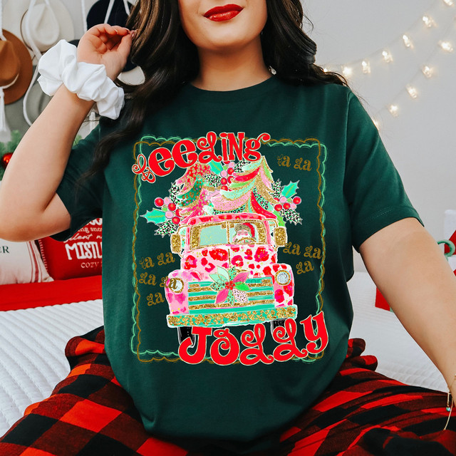 Feeling Jolly Pink Leopard Truck DTF Heat Transfer, Christmas holiday design on a dark green t-shirt featuring a festive truck with Christmas trees and holiday decorations.