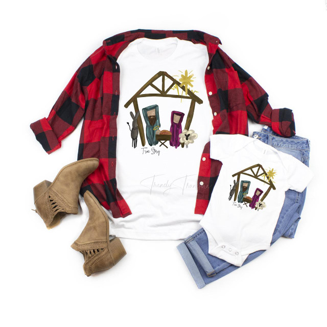 True Story Nativity Manger Scene Christmas Religious Sublimation Transfer, white t-shirts and a shirt with a nativity design, jeans, and tan boots. The design features a nativity scene with Mary, Joseph, baby Jesus, a donkey, and a star at the top, illustrated in a simple, colorful style.