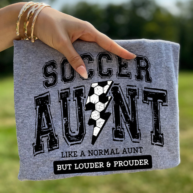 Soccer Auntie Loud & Proud DTF Heat Transfer, gray t-shirt with bold black text and a white lightning bolt design.