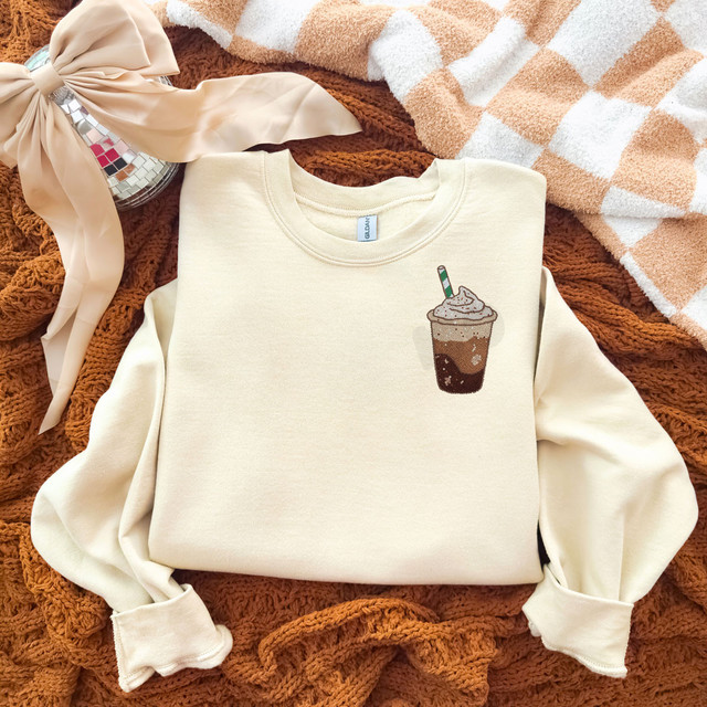 Faux Yarn Iced Coffee DTF Heat Transfer, fabric patch of iced coffee drink with whipped cream and a striped straw on a beige sweatshirt.